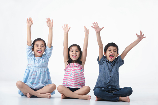 Indian, Asian Kid Girls and Boy Sitting , Laughing, Smiling with hand held high