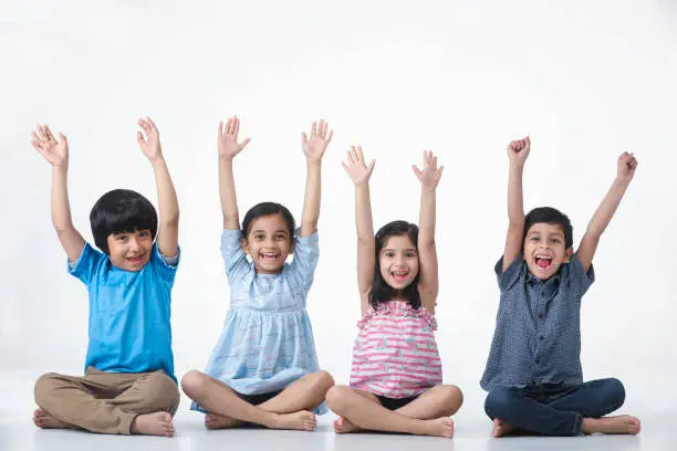 Indian, Asian Kid Girls and Boys Sitting , Laughing, Smiling with hand held high