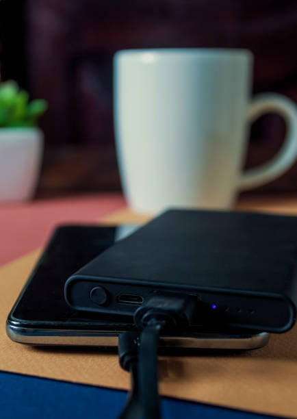 istock Mobile phone connected with black power bank on table 1248642873