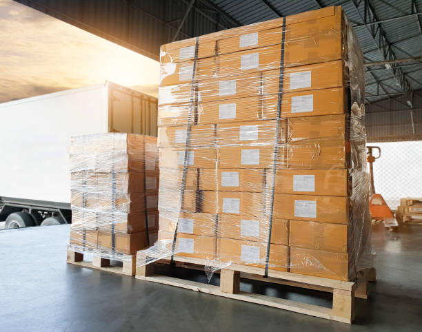 istock Road freight cargo shipment by truck. Large pallet goods waiting for load into caontainer truck at warehouse dock. 1248643863