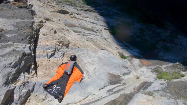 l’aviateur de costume d’aile saute outre de la crête de montagne - wingsuit photos et images de collection