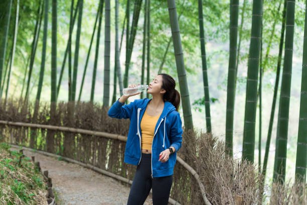 istock A young Asian woman resting and drinking water in a bamboo forest 1248647698