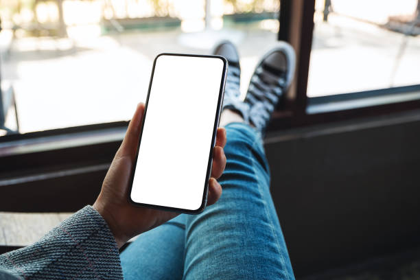 istock a woman holding mobile phone with blank white desktop screen  while sitting in cafe 1248649651