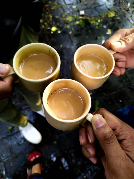 istock Cheering three friends with holding tea cup together in wet rainy climate 1248650541