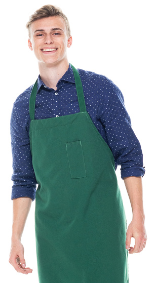Front view of aged 16-17 years old with short hair caucasian teenage boys standing in front of white background wearing apron who is happy