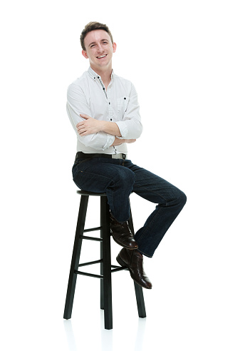 One person of aged 20-29 years old with brown hair caucasian male resting in front of white background wearing button down shirt who is confident with arms crossed