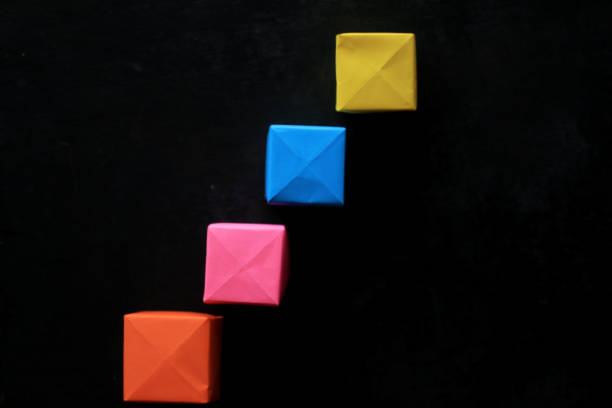 Colorful blank origami paper cubes for creative notes and any idea concept on black background.  Business plans and strategy concept with four blank notes of paper boxes.