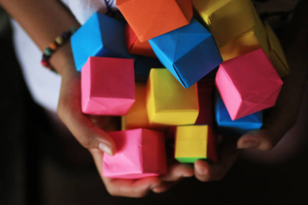 istock Colorful origami paper cubes in hand. 1248659971
