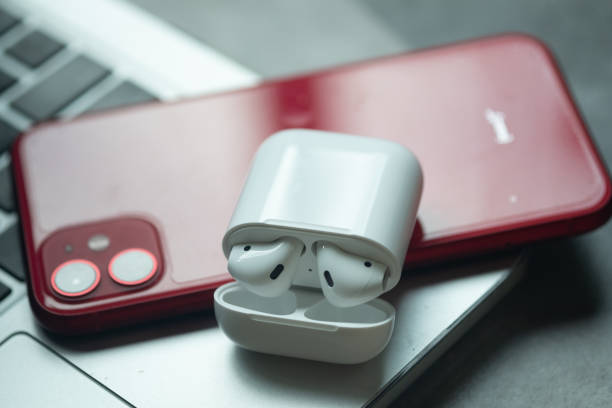 Apple Airpods wireless Bluetooth headphones and Iphone 11 Red color put on Macbook Bangkok, Thailand - June 10, 2020: Apple Airpods wireless Bluetooth headphones and Iphone 11 Red color put on Macbook mac plus stock pictures, royalty-free photos & images