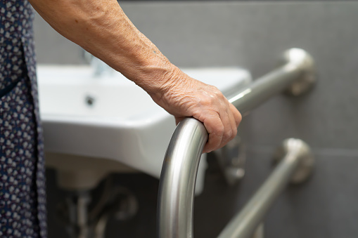 Asiático mayor o anciano anciana mujer paciente uso de inodoro de baño mango seguridad en la sala de hospital de enfermería : concepto médico fuerte saludable. photo