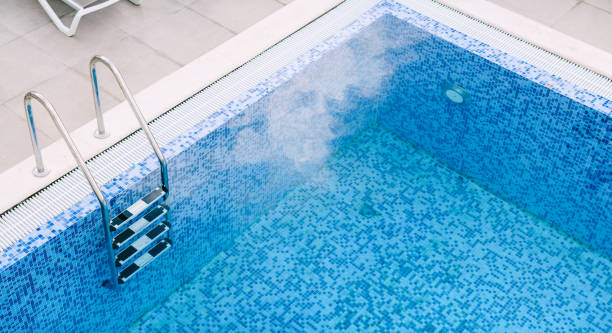 istock A chrome staircase with railings in a pool with blue mosaic. 1248662892