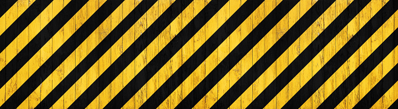 banner of wooden boarding painted black and yellow restricted area marking