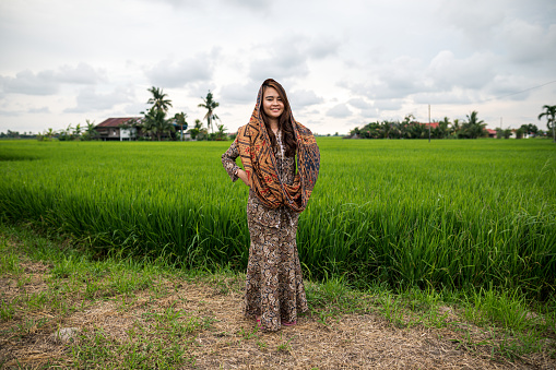 Young women standing in front of paddy field