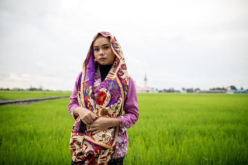 Young people walking at paddy field in the villageYoung women standing in front of paddy field