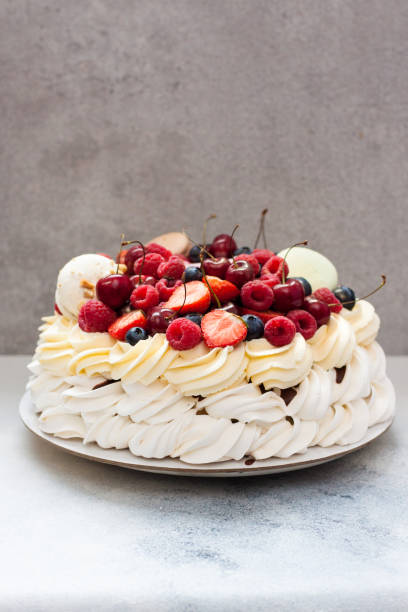 istock Pavlova meringue cake with fresh berries and macaroons on plain grey background. Copy space. 1248664445