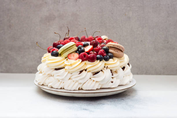 istock Pavlova meringue cake with fresh berries and macaroons on plain grey background. Copy space. 1248664451