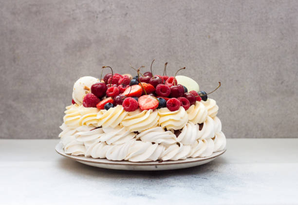 istock Pavlova meringue cake with fresh berries and macaroons on plain grey background. Copy space. 1248664453