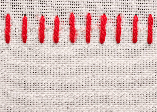 istock Red embroidery stitches on tan fabric 124866553