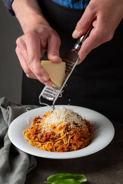 istock Men serving spaghetti with cheese, italian food 1248673221