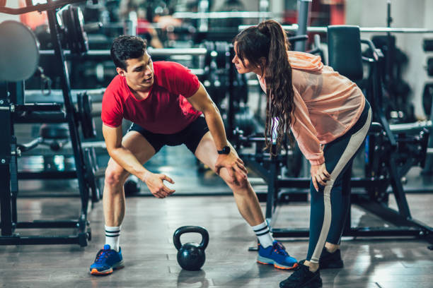 istock Young beautiful woman doing exercises with personal trainer 1248676112