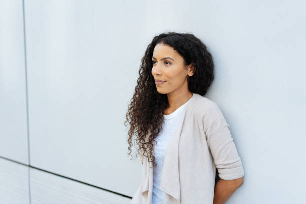 istock Young woman relaxing against a wall thinking 1248676286