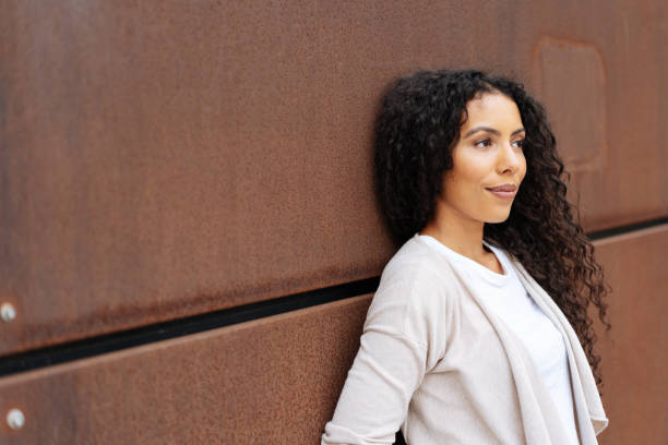 istock Attractive woman relaxing against a brown wall 1248676288