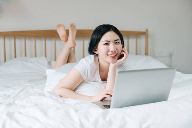 istock Young Asian girl using laptop in bed 1248677407