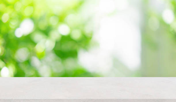 istock abstract blurred garden view form living room window with concrete table background for show , promote ,design banner ads on display concept 1248678335