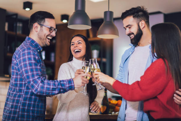 istock Young people cheering with champagne flutes and looking happy while having home party. 1248681897