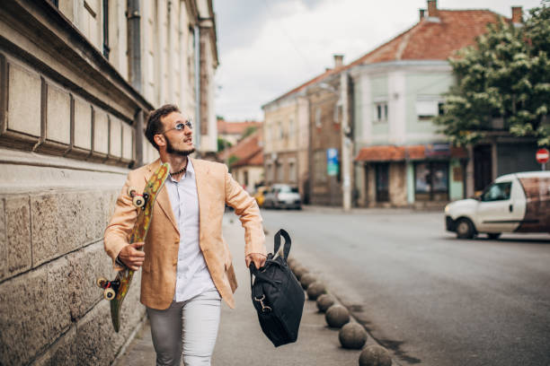 istock One young modern businessman with skateboard running to work on rainy day 1248682808