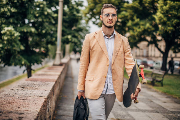 istock One young handsome businessman carrying skateboard on the way to work 1248683160