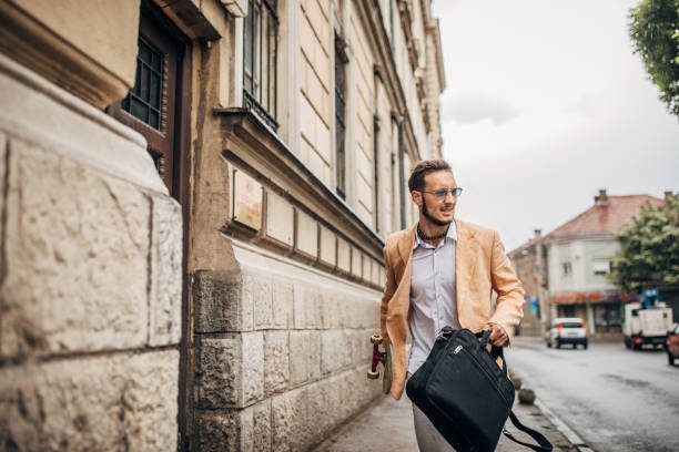 istock One modern man with skateboard running to work on rainy day 1248683610