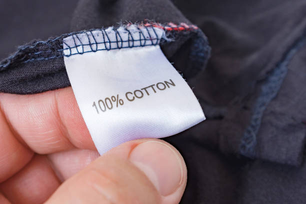 istock Men's hand holding clothes label 