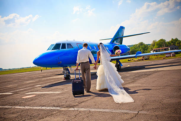 A bride and groom boarding a plane