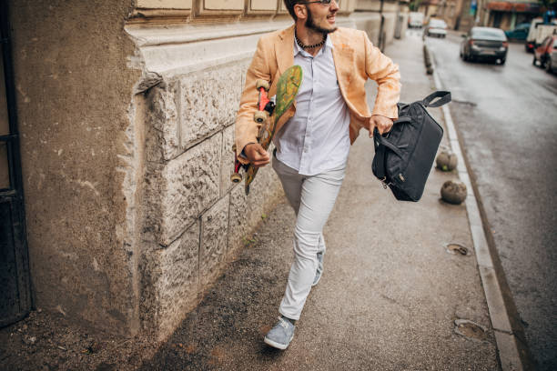 istock Handsome businessman with skateboard running to work on rainy day 1248686229