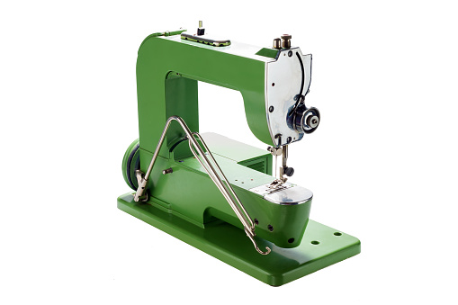 side view of an old vintage green sewing machine on white background
