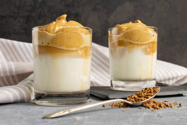 istock Two Dalgona / whipped coffee glasses on a concrete table with a spoon of instant coffee and a linen towel 1248687723