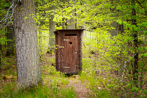 Outhouse in snowy woods of a nature preserve