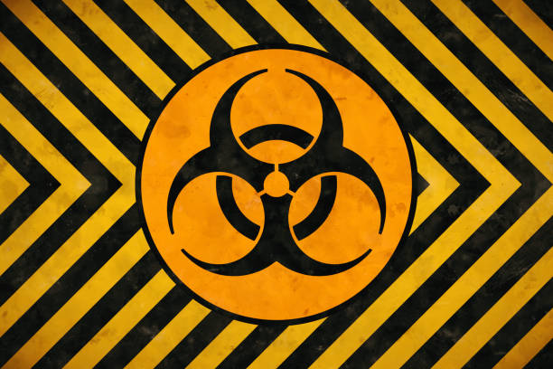 istock Biohazard symbol design silhouette in black and orange inside a circle on yellow and black warning stripes pattern background 1248688147