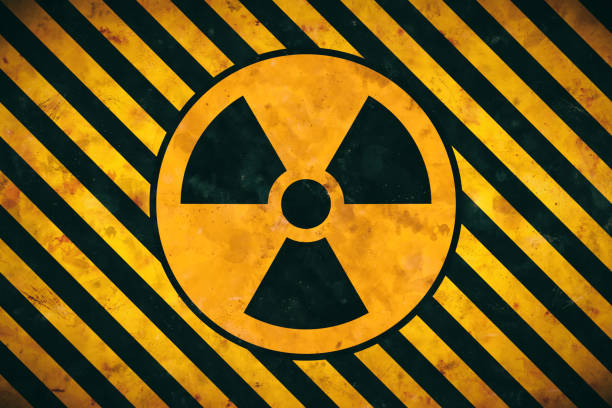 istock Radioactive symbol design silhouette in black and orange inside a circle on warning stripes pattern background 1248688165