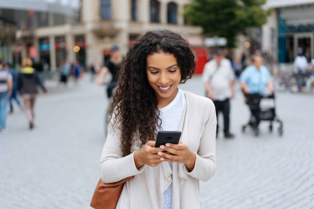 istock Pretty woman texting on mobile on city square 1248689477