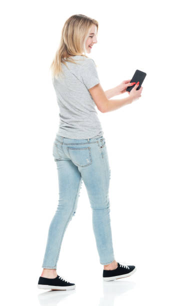 geração z feminina na frente do fundo branco vestindo camiseta e usando telefone inteligente - teenager smart phone young women teenagers only - fotografias e filmes do acervo