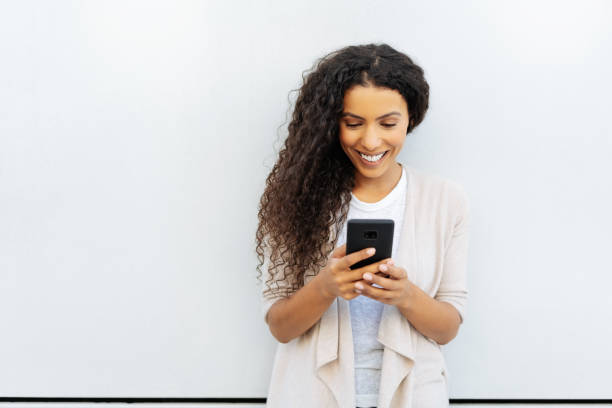istock Cute young woman reading a mobile phone message 1248689810