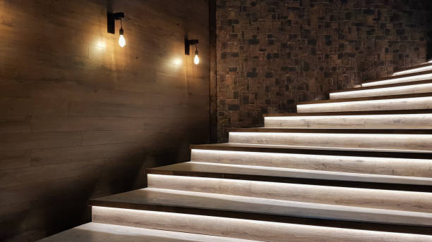 Illuminated staircase with wooden steps and illuminated at night in the interior of a large house Illuminated staircase with wooden steps and illuminated at night in the interior of a large house. caution step stock pictures, royalty-free photos & images