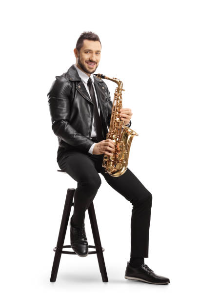 istock Man in a leather jacket sitting on a chair and holding a saxophone 1248691791