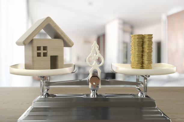 istock House and coins on the scale 1248694010