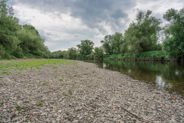 istock Flat gravel bank on a small river on a cloudy day. Upstream. 1248698152