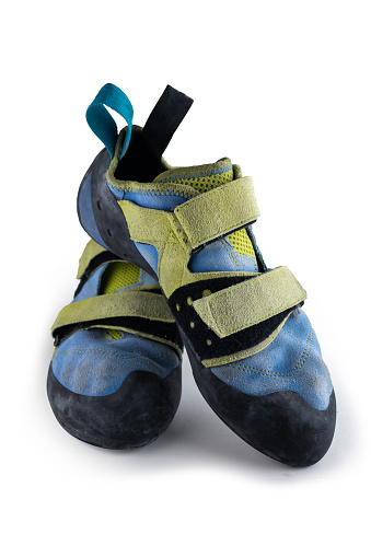 Isolated climbing shoes in a white background. Old, used blue and yellow rock climbing shoes
