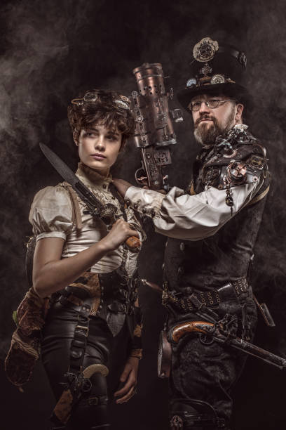 Steampunk couple in a studio shot Steampunk couple of male and female enthusiasts in a studio shot steampunk pistol pictures stock pictures, royalty-free photos & images