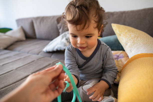 istock Curious little boy taking shoelace from his father's hand 1248703126